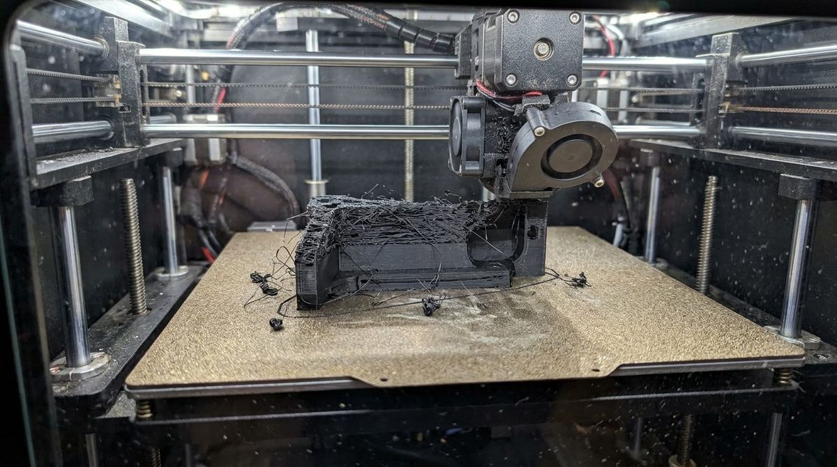 Failed 3D printed mechanical bracket on build plate due to extruder gear filament grinding